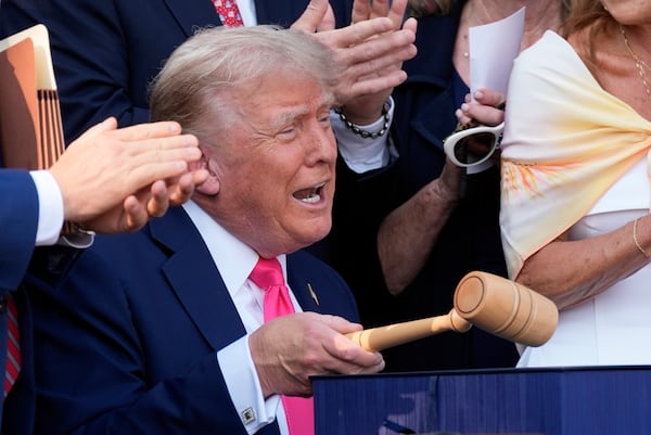 President Donald Trump bangs a gavel after signing his signature bill of tax breaks and spending cuts at the White House in Washington, Friday, July 4, 2025.(AP Photo/Alex Brandon, Pool)