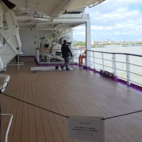 A man walks on a deck of the British cruise ship the Ambition after 1,700 passengers and crew were ordered to remain on board after an outbreak of gastrointestinal illness, in the port of Bordeaux, France, Wednesday, May 13, 2026. (Kevin Starrs via AP)