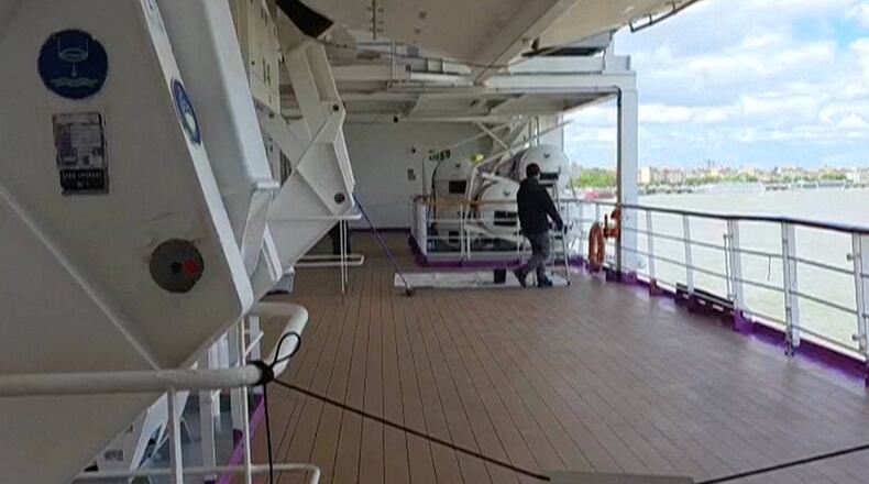 A man walks on a deck of the British cruise ship the Ambition after 1,700 passengers and crew were ordered to remain on board after an outbreak of gastrointestinal illness, in the port of Bordeaux, France, Wednesday, May 13, 2026. (Kevin Starrs via AP)