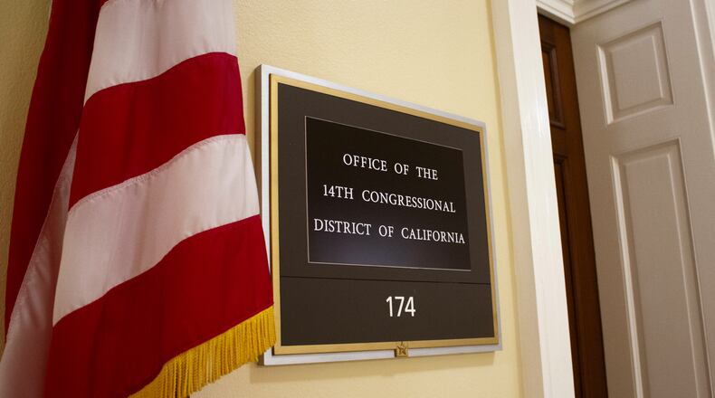 An American flag stands outside the office of California's 14th Congressional District in the Cannon House Office Building in Washington, Monday, July 20, 2026. (AP Photo/Tallulah Brown Van Zee)