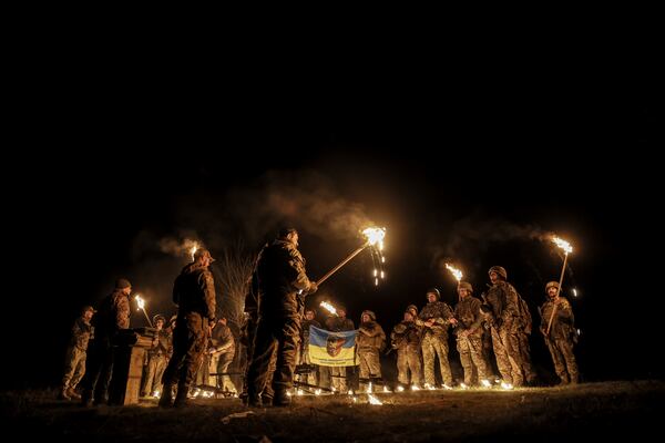 In this photo taken on March 21, 2025 and provided by Ukraine's 24th Mechanized Brigade press service on March 24, 2025, servicemen attend a dedication ceremony for soldiers near the frontline in the Donetsk region, Ukraine. (Oleg Petrasiuk/Ukraine's 24th Mechanized Brigade via AP)