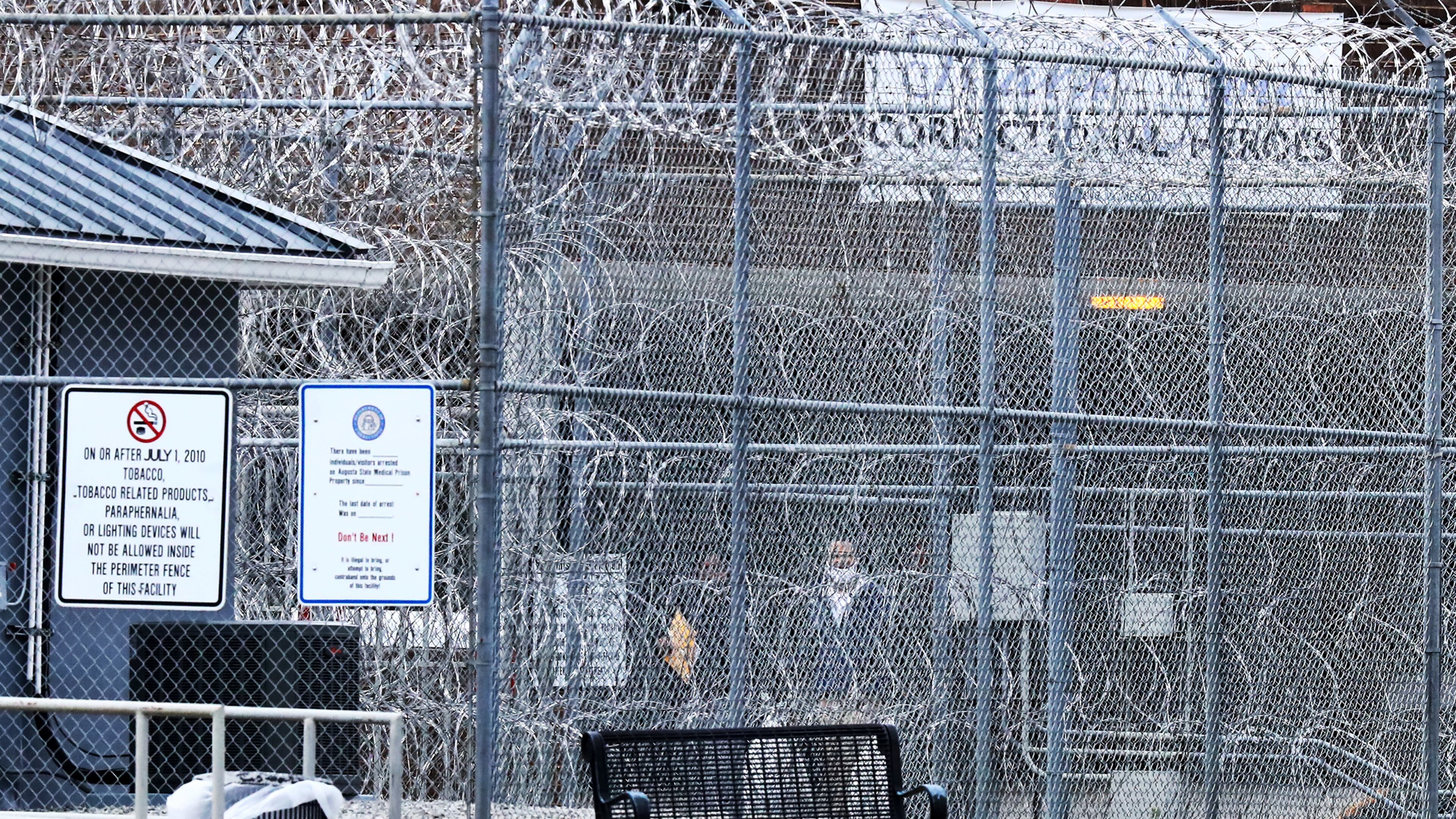 Devonia Inman (center wearing mask) is led past rows of barbed wire to freedom out of the Augusta State Medical Prison after being released from custody after serving 23 years in prison for a wrongful conviction on Monday, Dec 20, 2021, in Grovetown. His charges were dismissed in a murder case. (AJC file photo)