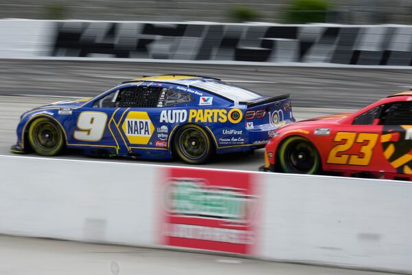 Chase Elliott (9) leads Bubba Wallace (23) into Turn 2 during a NASCAR Cup Series auto race in Martinsville, Va., Sunday, March 30, 2025. (AP Photo/Chuck Burton)
