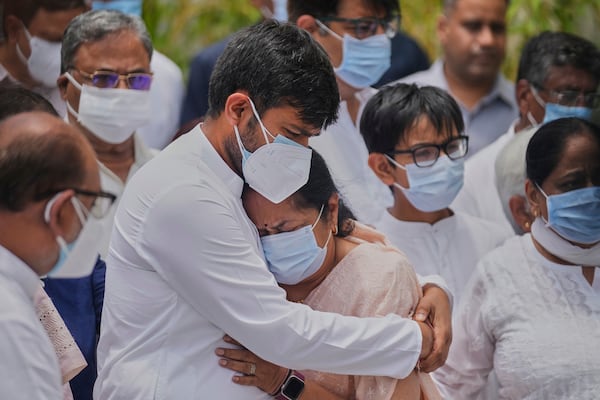 Anjali Rupani, the wife of former Chief Minister of Gujarat Vijay Rupani, who died in the Air India plane crash, is comforted by her son during a wreath-laying ceremony outside the mortuary of a hospital in Ahmedabad, India, Monday, June 16, 2025. (AP Photo/Rafiq Maqbool)
