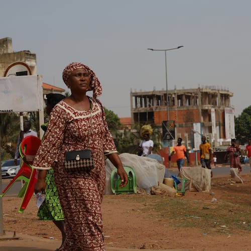People walk on the street in Bissau, Guinea-Bissau, Wednesday, Nov. 26, 2025. (AP Photo/Darcicio Barbosa)