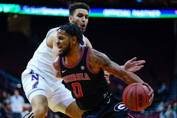 Georgia's Jailyn Ingram, right, drives past Northwestern's Pete Nance during the first half of an NCAA college basketball game Tuesday, Nov. 23, 2021, in Newark, N.J. (AP Photo/Frank Franklin II)