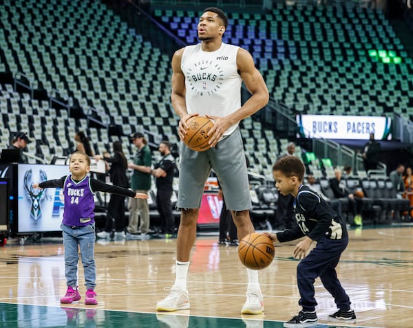 Milwaukee Bucks forward Giannis Antetokounmpo, center, warm up with his sons Maverick Shai, left, and Liam Charles, right, before Game 4 of an NBA basketball first-round playoff series against the Indiana Pacers, Sunday, April 27, 2025, in Milwaukee. (AP Photo/Jeffrey Phelps)
