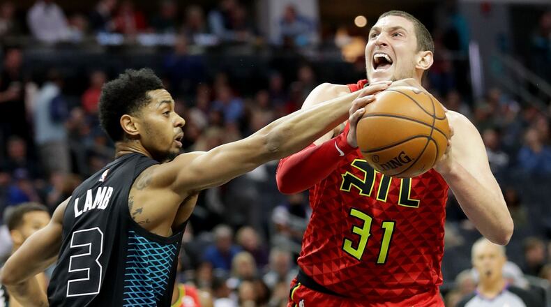 Jeremy Lamb of the Charlotte Hornets tries to stop Mike Muscala of the Atlanta Hawks during their game at Spectrum Center on January 26, 2018 in Charlotte, North Carolina.