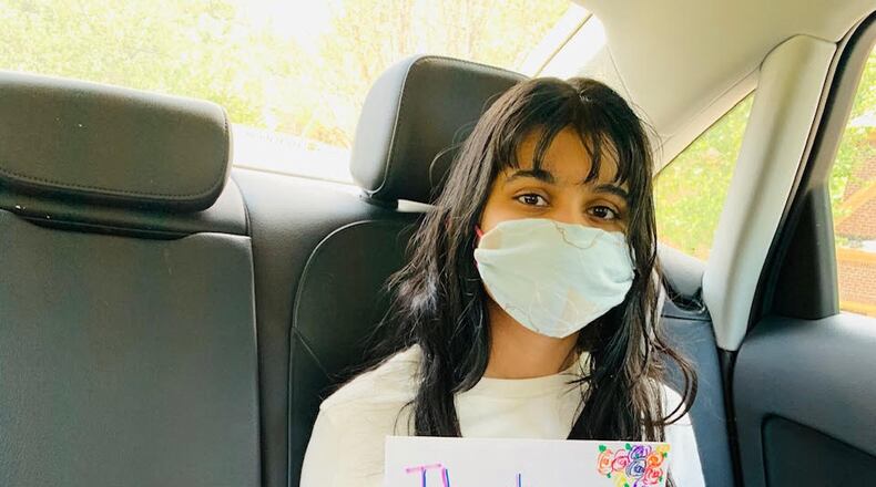 Aditi Mohan is pictured in a car with a box of ear savers in her lap.