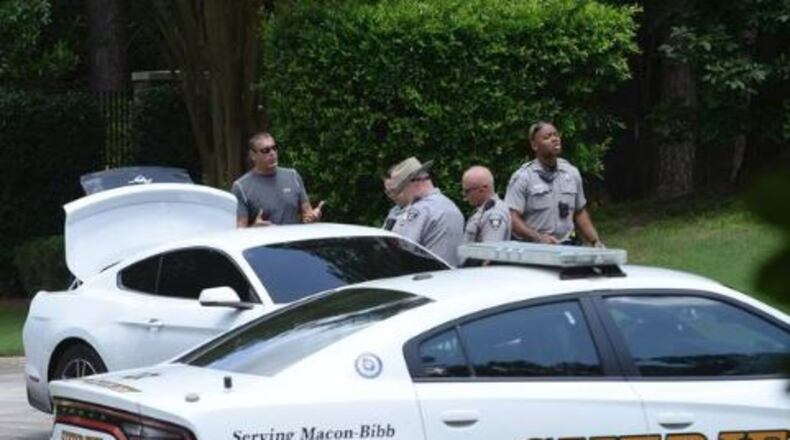 Former major league pitcher Kevin Brown (left) speaks with Bibb County deputies after reportedly capturing two mail-theft suspects.