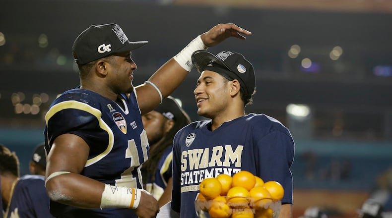 Georgia Tech quarterback Justin Thomas, right, is congratulated by running back Synjyn Days after Thomas was presented with the MVP trophy after Georgia Tech defeated Mississippi State 49-34 in the Orange Bowl NCAA college football game, Wednesday, Dec. 31, 2014, in Miami Gardens, Fla. (AP Photo/Wilfredo Lee)