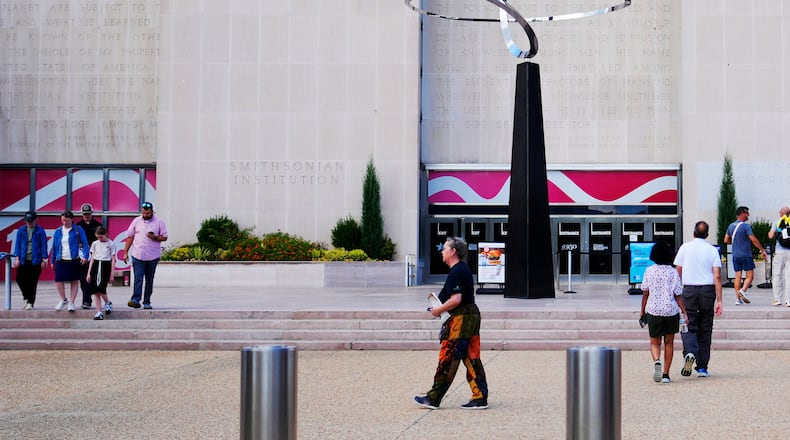 People walking past the "Infinity" sculpture outside the Smithsonian National Museum of American History on the National Mall in Washington, Tuesday, Sept. 8, 2026. (AP Photo/Pablo Martinez Monsivais)