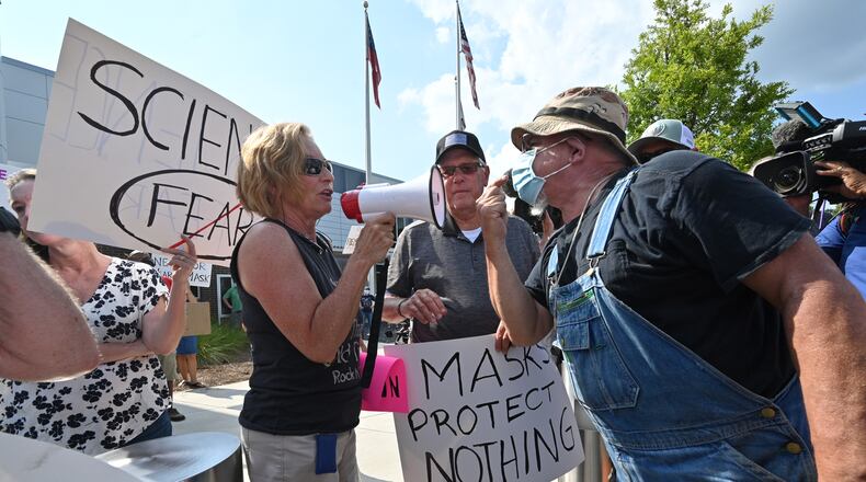 A demonstrator (right) demanding mask-mandate confronts a counter-protester at a rally in the parking lot of Cobb County School District's headquarters on Aug. 12, 2021. (Hyosub Shin / Hyosub.Shin@ajc.com)