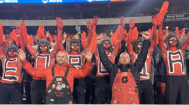 Mike Woods Jr. (front left in black overalls), known as Little Mike, and his brother Trent Woods (front right in red overalls) join the University of Georgia paint line to cheer on the Bulldogs in their game against Auburn on Oct. 8, 2022 at Sanford Stadium in Athens. The Woods brothers have been keeping alive the family tradition of painting one's bald head with the UGA logo. Trent Woods died in February 2024. (Photo courtesy of Mike Woods)