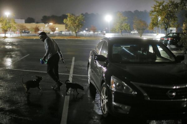 Krystina Brown walks her dogs before dawn each day.  A  veteran, Brown is temporarily homeless, and said she sleeps in her car with her dogs, Dinero and Karat.   BOB ANDRES / BANDRES@AJC.COM