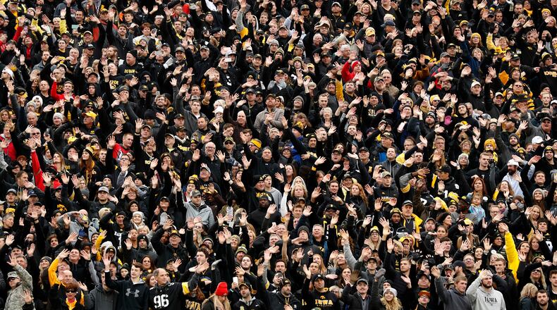In this Nov. 4, 2017, photo, Iowa fans wave to children in the University of Iowa's children's hospital at the end of the first quarter of an NCAA college football game against Ohio State in Iowa City, Iowa. In the new tradition, known as The Wave, at the end of the first quarter fans in the 70,585-seat Kinnick Stadium turn to wave to the pediatric patients watching from the hospital, a 12-story building that overlooks the stadium from across the street. (AP Photo/Charlie Neibergall)