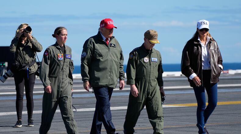President Donald Trump and first lady Melania Trump walk on the flight deck as part of the Navy's 250th anniversary celebration, aboard the USS George H.W. Bush aircraft carrier in the Atlantic Ocean off the coast of Norfolk, Va., Sunday, Oct. 5, 2025. (AP Photo/Alex Brandon)
