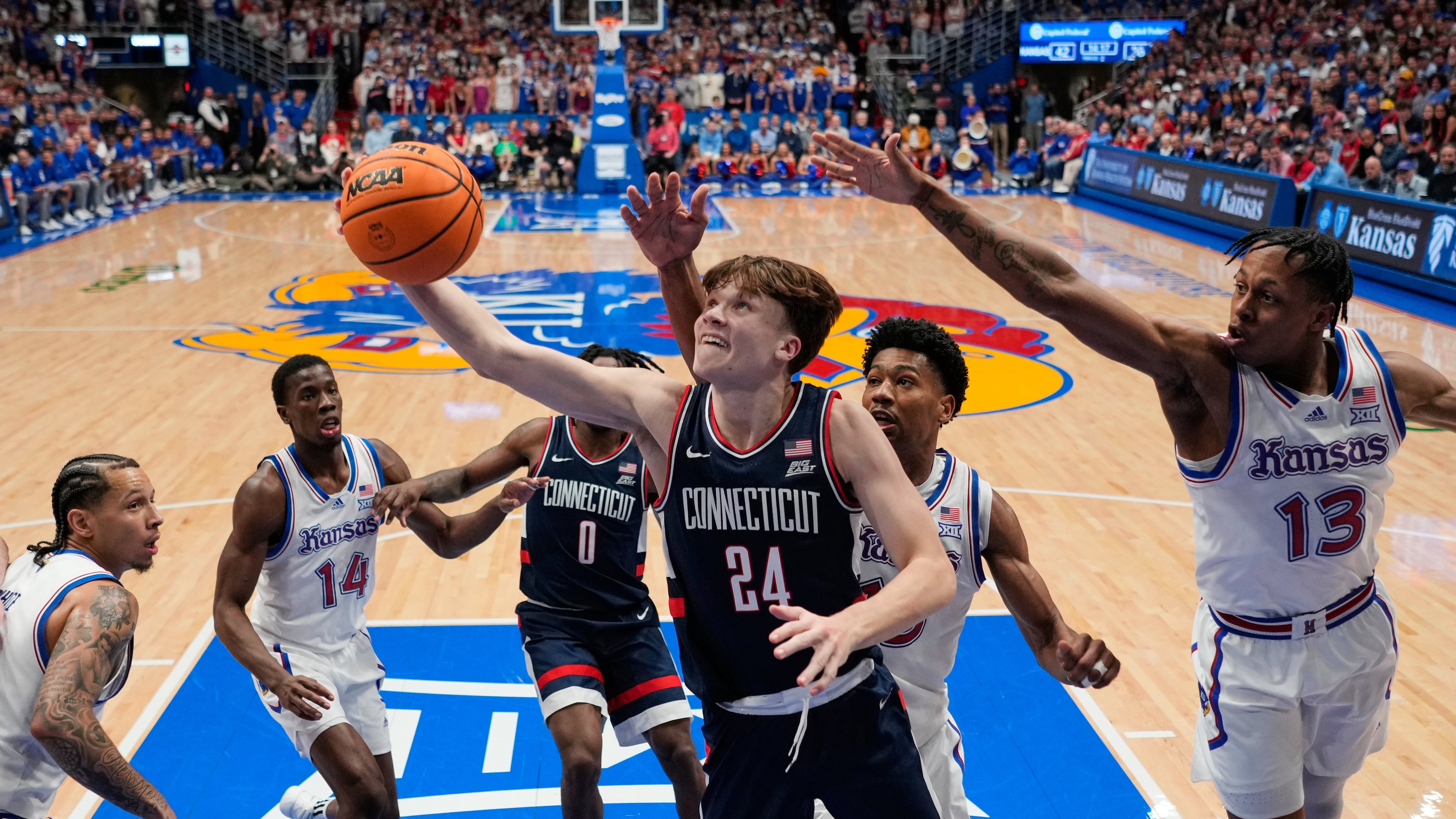 UConn guard Braylon Mullins (24) puts up a shot during the second half of an NCAA college basketball game against Kansas, Tuesday, Dec. 2, 2025, in Lawrence, Kan. (AP Photo/Charlie Riedel)