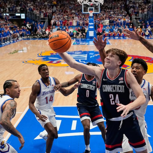UConn guard Braylon Mullins (24) puts up a shot during the second half of an NCAA college basketball game against Kansas, Tuesday, Dec. 2, 2025, in Lawrence, Kan. (AP Photo/Charlie Riedel)