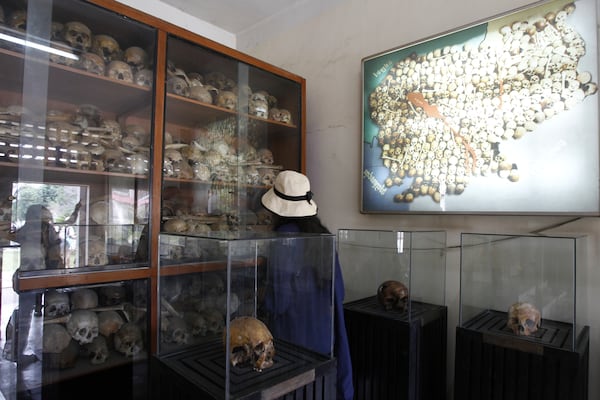 FILE - Tourists look at portraits of genocide victims in Khmer Rouge regime at the Tuol Sleng Genocide Museum, formerly the most notorious Khmer Rouge prison, in Phnom Penh, Cambodia, on July 10, 2014. (AP Photo/Heng Sinith, File)