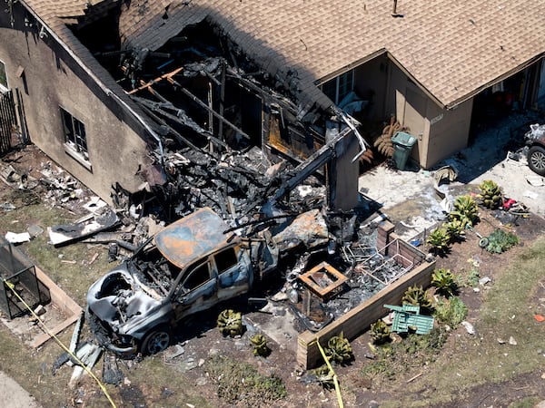 Debris covers the ground after a small plane crashed into a San Diego neighborhood, setting homes and cars on fire and forcing evacuations early Thursday, May 22, 2025. (AP Photo/William Liang)