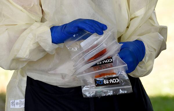 Catherine Spellman, LPN, secures COVID-19 tests conducted outside the Glynn County Health Department in Brunswick in July. (Ryon Horne/RHORNE@AJC.COM)