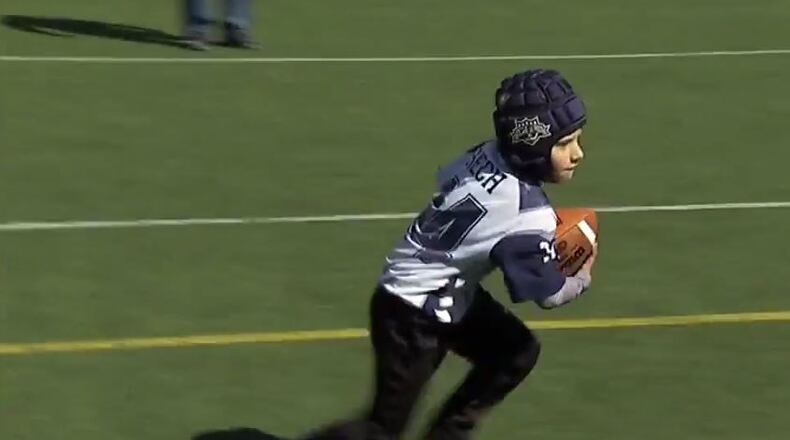A North Atlanta Football League player tries out a soft-shell helmet.