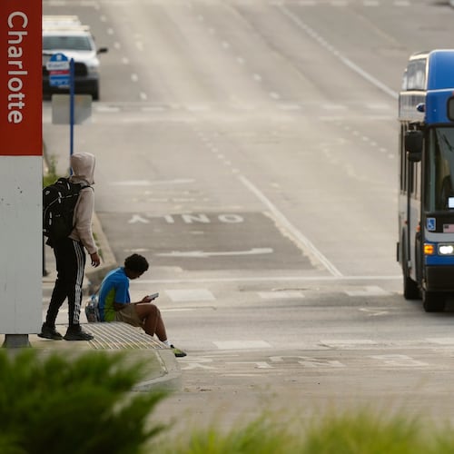 People wait for the bus at a transit center Friday, June 5, 2026, in Kansas City, Mo. (AP Photo/Charlie Riedel)