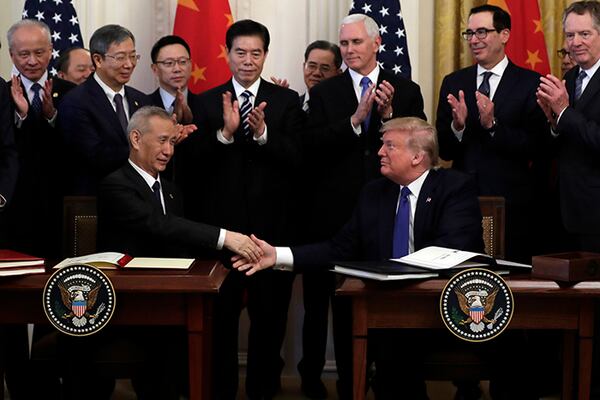 President Donald Trump shakes hands with Chinese Vice Premier Liu He, after signing a trade agreement Wednesday in the East Room of the White House. Trump hailed the long-sought agreement as a "momentous step" that was "righting the wrongs of the past."