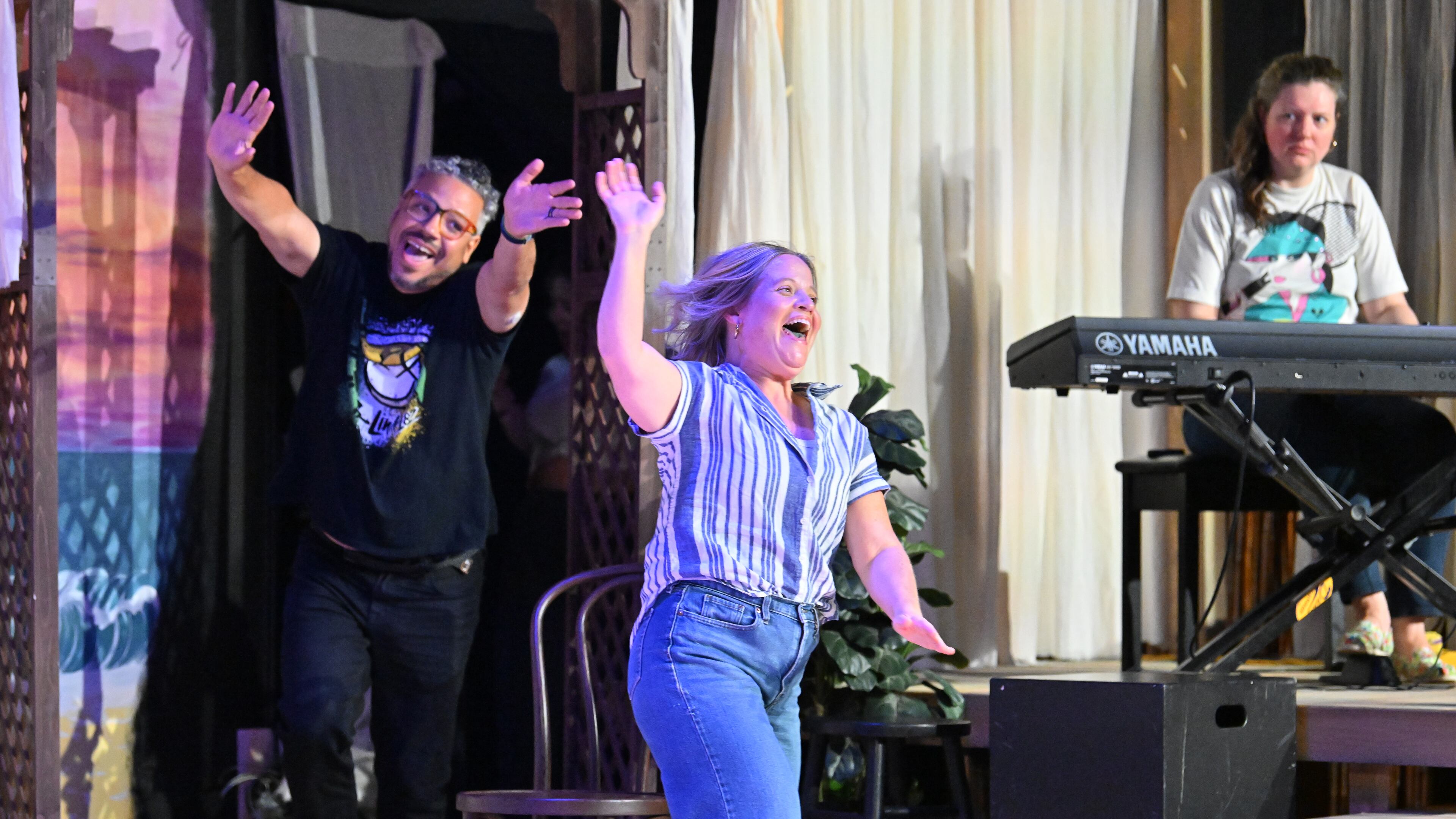 Dad's Garage ensemble members Maged Roushdi (left) and Karen Cassady (center) participate in TheatreSports 30th anniversary show at Dad’s Garage on Friday, July 25, 2025, in Atlanta. Keyboardist Sydney Ellis elevates the comedy with sound effects. (Hyosub Shin/AJC)