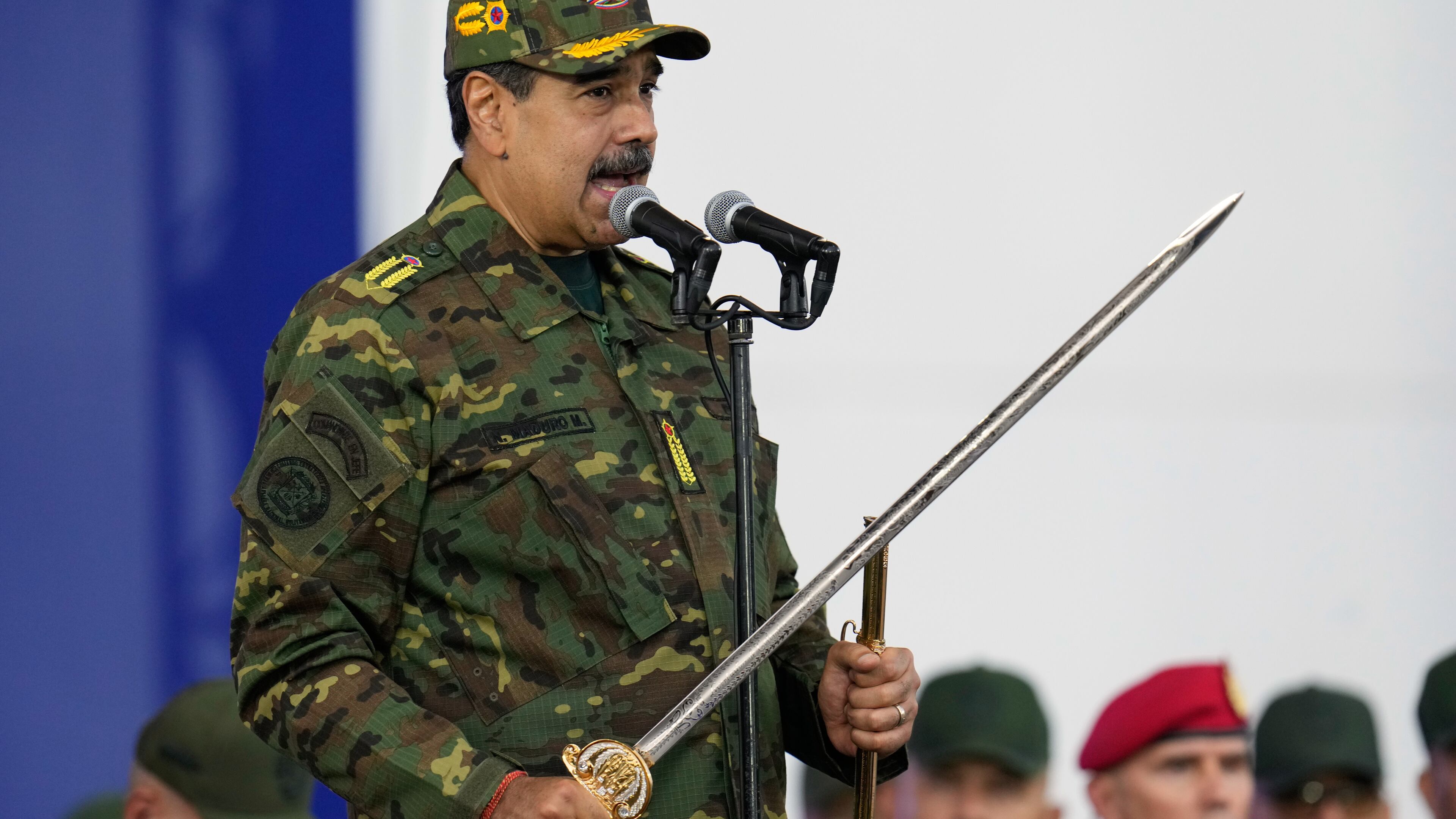 Venezuelan President Nicolas Maduro holds a ceremonial sword said to have belonged to independence hero Simon Bolivar during a government-organized civic-military march in Caracas, Venezuela, Tuesday, Nov. 25, 2025. (AP Photo/Ariana Cubillos)