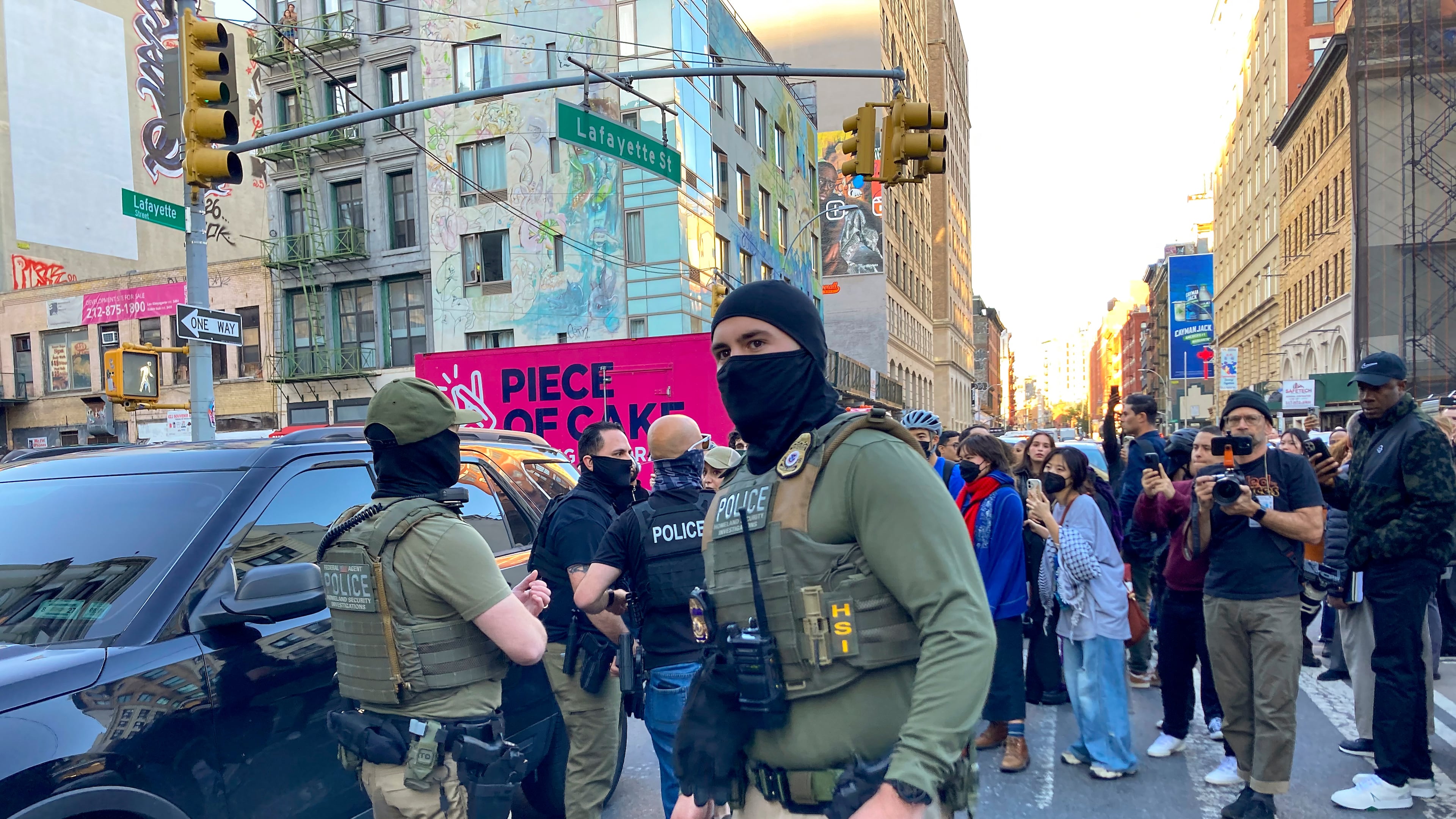 Federal agents conduct an immigration sweep on Canal Street in Chinatown as protestors gather, Tuesday, Oct. 21, 2025, in New York. (AP Photo/Jake Offenhartz)