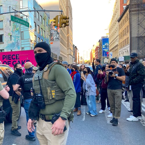 Federal agents conduct an immigration sweep on Canal Street in Chinatown as protestors gather, Tuesday, Oct. 21, 2025, in New York. (AP Photo/Jake Offenhartz)