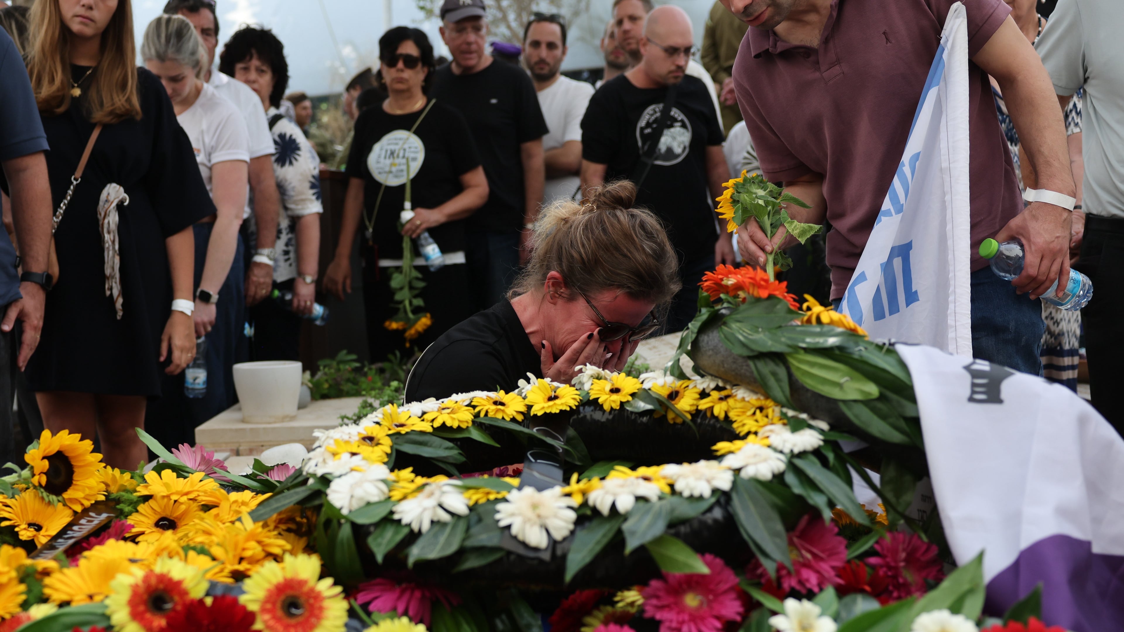 People mourn at the grave of Hadar Goldin an Israeli soldier killed in Gaza in 2014 and whose body had been held there until it was released Sunday, during his funeral in Kfar Saba, Israel, Tuesday, Nov. 11, 2025. (Abir Sultan/Pool via AP)