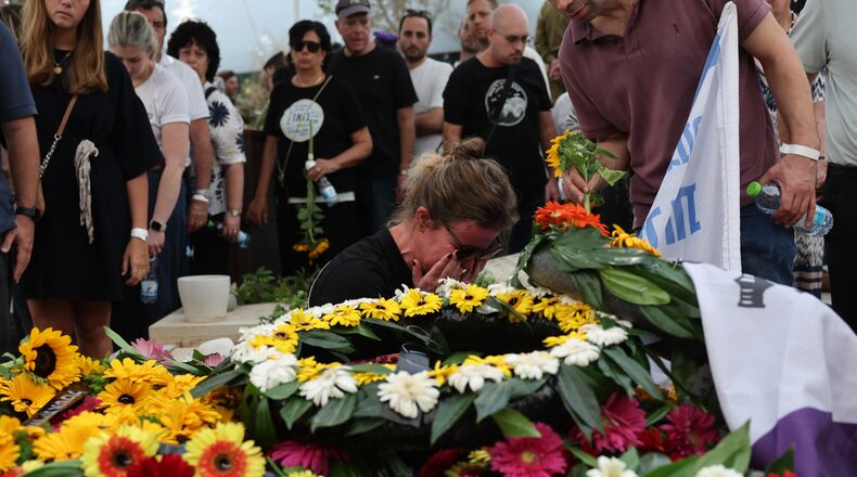 People mourn at the grave of Hadar Goldin an Israeli soldier killed in Gaza in 2014 and whose body had been held there until it was released Sunday, during his funeral in Kfar Saba, Israel, Tuesday, Nov. 11, 2025. (Abir Sultan/Pool via AP)