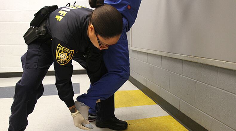 Deputy P. Brown performs a search at the Gwinnett County Jail, which participates in the federal 287(g) immigration enforcement program.