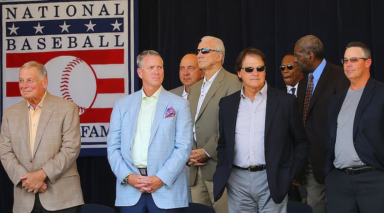 Bobby Cox (from left), Tom Glavine, Tony La Russa, Greg Maddux, Frank Thomas and Joe Torre stand on the stage during an awards presentation at Doubleday Field before participating in the Hall of Fame Legends Parade on Saturday in Cooperstown. CURTIS COMPTON / CCOMPTON@AJC.COM