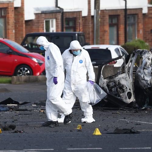 Forensic investigators inspect the site of a car bomb that exploded outside Dunmurry police station in South Belfast, Sunday, April 26, 2026. (AP Photo/Peter Morrison)