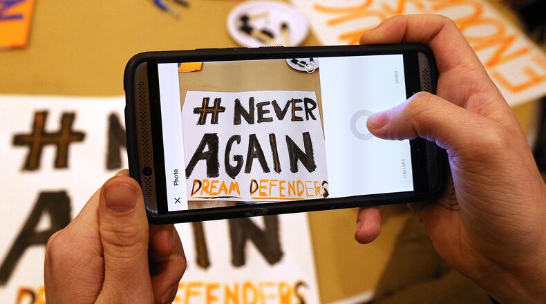 Eve Harclerode of Sutton Middle School, snaps a photo to send out on social media of one of the signs students made for the March for Our Lives at the Central Presbyterian Church on Wednesday, March 21, 2018, in Atlanta. Curtis Compton/ccompton@ajc.com