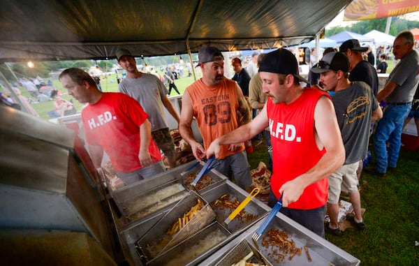 Members of the Hinsdale, N.H., Fire Department make fresh fries during the annual fireworks show on Thursday, July 3, 2025. (Kristopher Radder/The Brattleboro Reformer via AP)