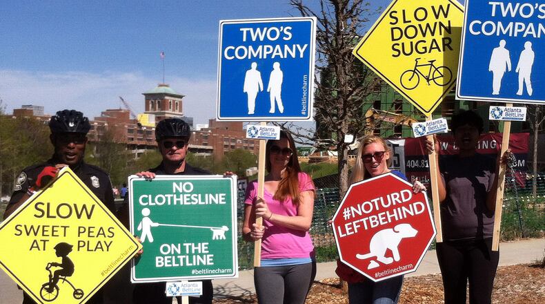 Volunteers and some members of the Atlanta Police Department's Path Force unit, which patrols the Beltline, with signs that were used during a recent fun etiquette campaign. The open sections of trail have already proven so popular that with summer approaching, users and Beltline officials are all emphasizing the need to politely share the outdoor space.