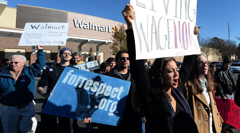 Misty Novitch holds up her “Living Wage Now” sign during the protest at the Walmart on Martin Luther King Jr Drive on Friday, November 29, 2013. Atlanta Jobs with Justice protested at the Walmart store on Martin Luther King Drive and Howell Mill Road on Friday, November 29, 2013. The event is part of a nationwide protest of the chain’s labor practices, wages and its push to open on Thanksgiving Day, forcing thousands of its employees to work the family holiday. JOHNNY CRAWFORD / JCRAWFORD@AJC.COM