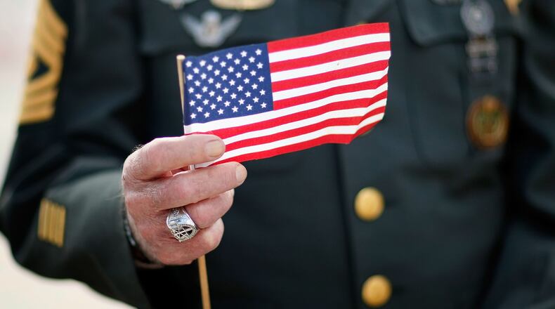 Army special forces vet Tony Junot holds an American flag during a Veterans Day ceremony November 12, 2007 in Miami Beach, Florida. Veterans Day honors military veterans from all wars that the United States has fought.  (Photo by Joe Raedle/Getty Images)