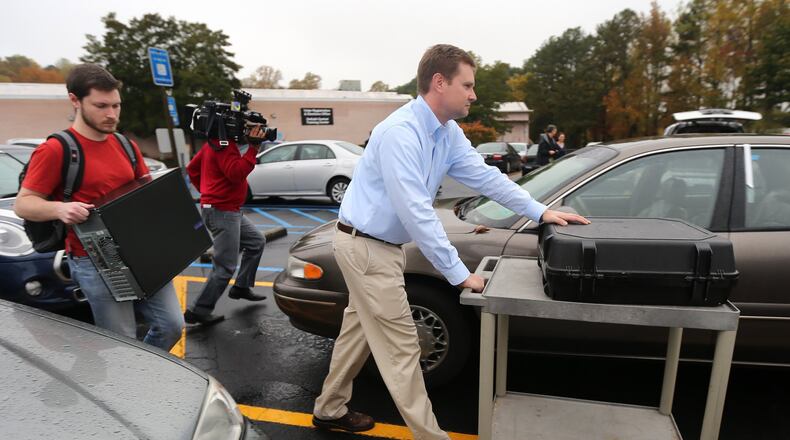 Investigators take a voting machine and a desktop computer from the DeKalb County elections office on Thursday. (Ben Gray / bgray@ajc.com)