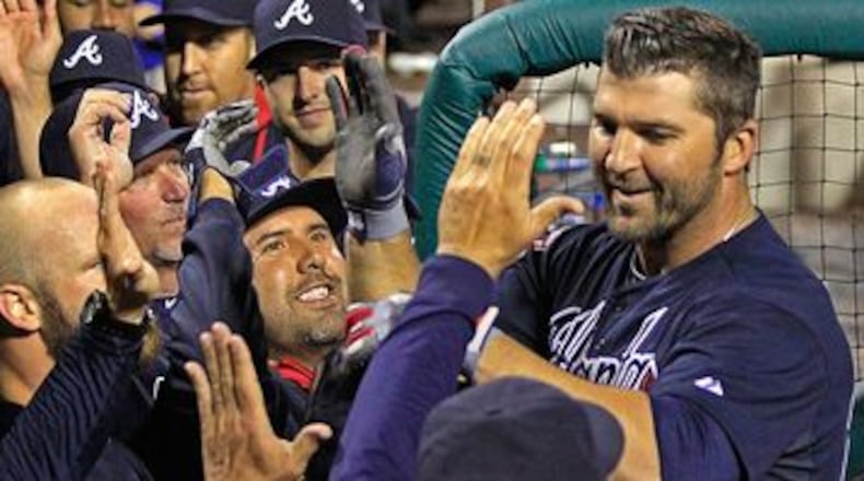 Dan Uggla celebrates with teammates after ninth-inning grand slam Monday. (AP photo)