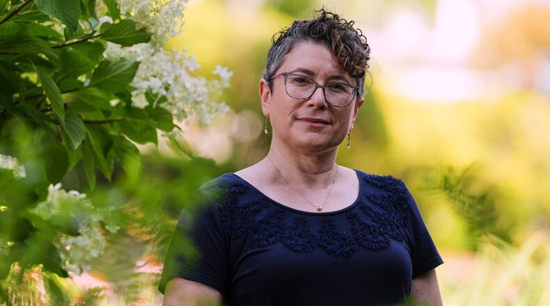 Ziva Mann, mother of a transgender child and member of a welcoming synagogue, poses in her garden, Wednesday, Aug. 13, 2025, in Newton, Mass. (AP Photo/Charles Krupa)
