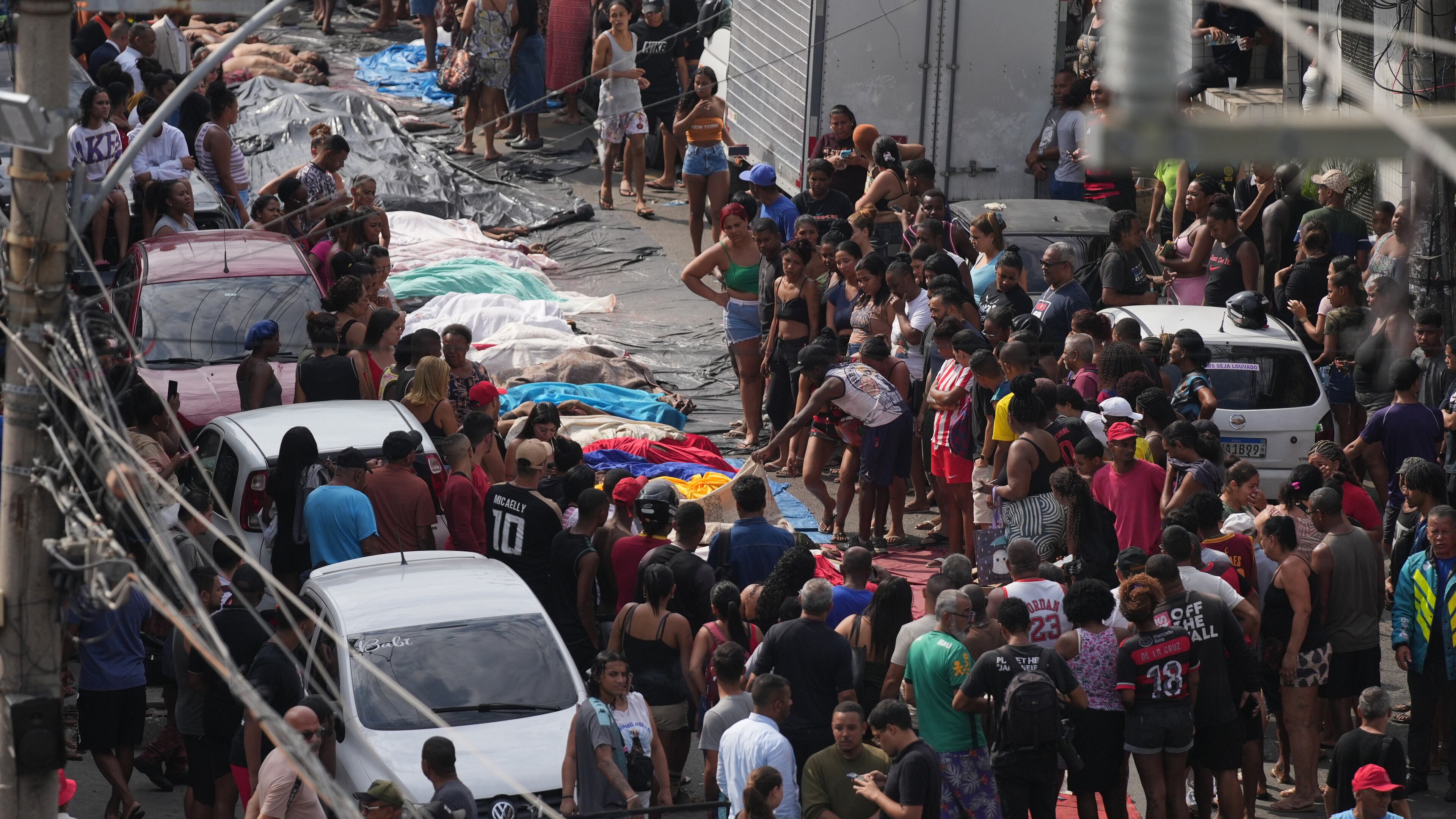 Residents look at the bodies of people killed the day before during a police raid targeting the Comando Vermelho gang in the Complexo da Penha favela of Rio de Janeiro, Brazil, Wednesday, Oct. 29, 2025. (AP Photo/Silvia Izquierdo)