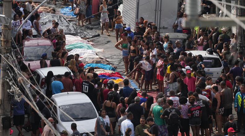 Residents look at the bodies of people killed the day before during a police raid targeting the Comando Vermelho gang in the Complexo da Penha favela of Rio de Janeiro, Brazil, Wednesday, Oct. 29, 2025. (AP Photo/Silvia Izquierdo)