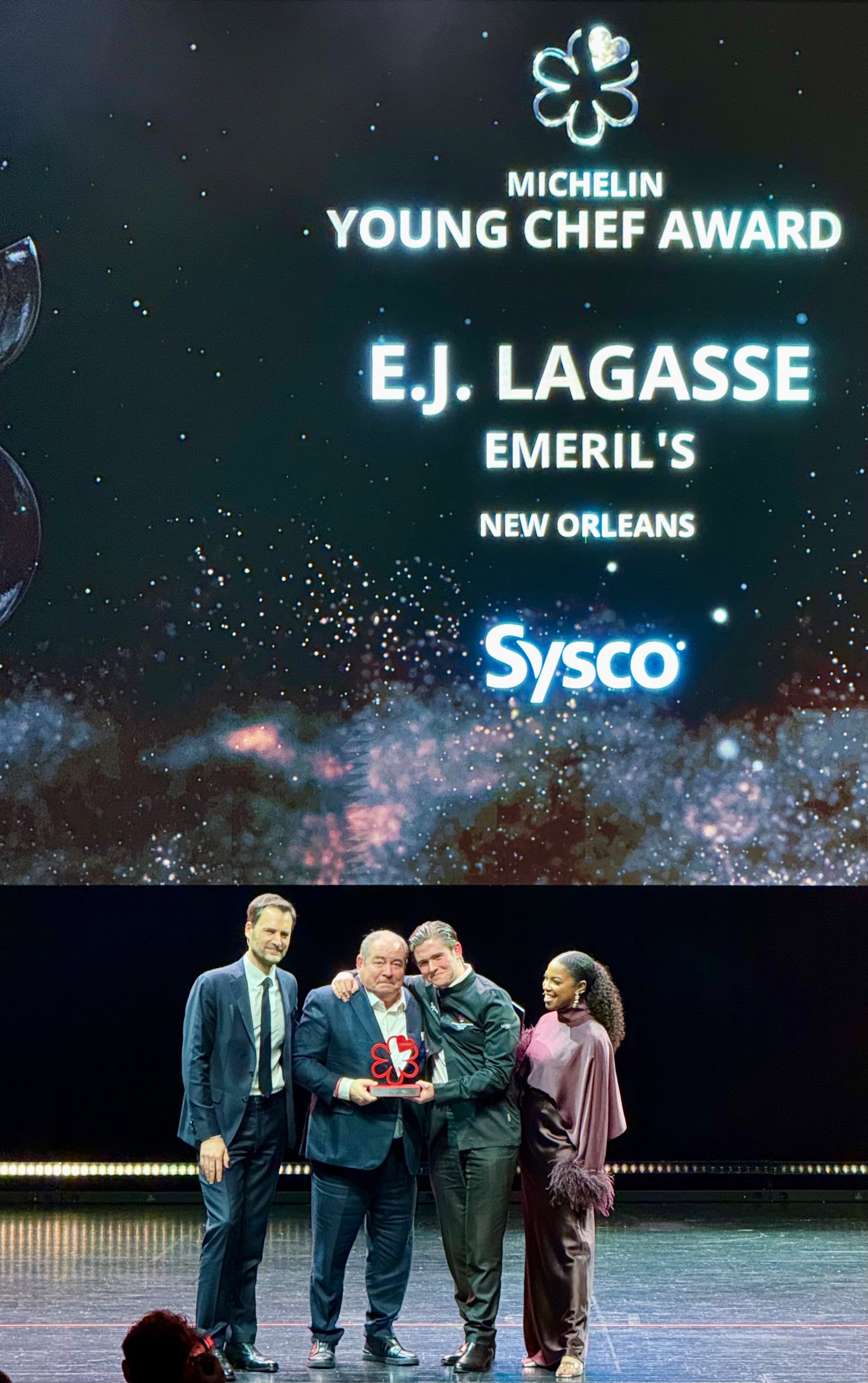Chef EJ Lagasse (second from right) stands with his father, Emeril Lagasse (second from left), after receiving two Michelin stars for their New Orleans restaurant Emeril's. (Henri Hollis / AJC)