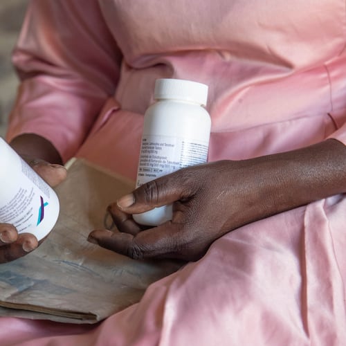 FILE - Florence Makumene holds HIV medication that she received through funding from the U.S. President's Emergency Plan for AIDS Relief (PEPFAR), along with her hospital records book, at her home in Harare, Zimbabwe, Feb. 7, 2025. (AP Photo/Aaron Ufumeli, File)